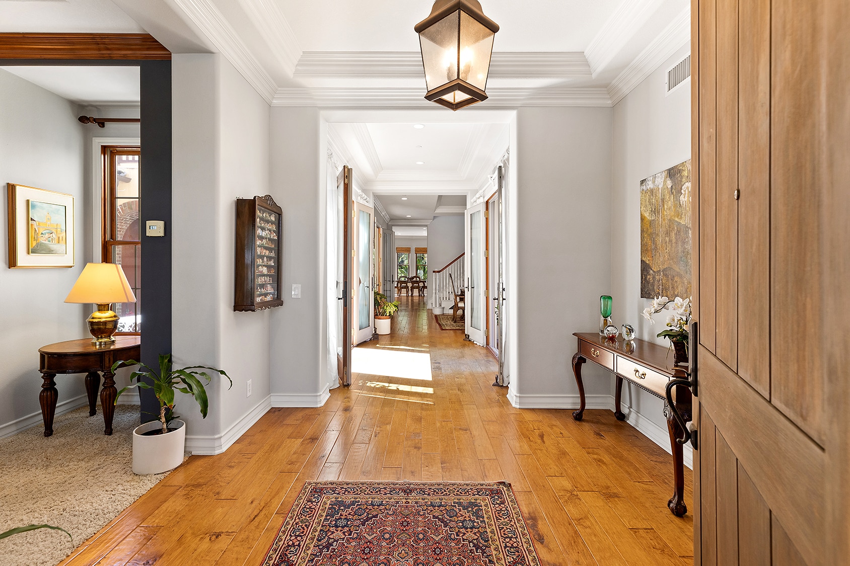 Luxury home entryway with hardwood floors and long hallway