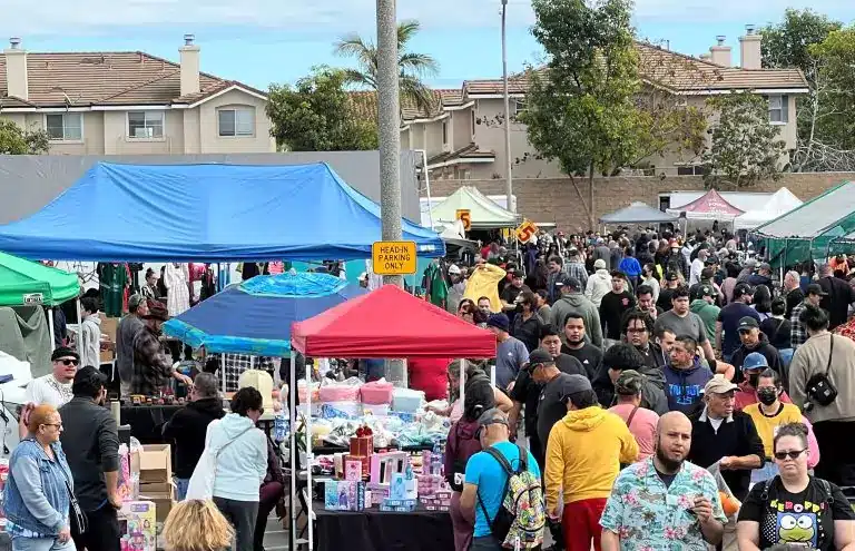 View of Cypress College Swap Meet packed full of people walking and shopping at vendor booths and tents