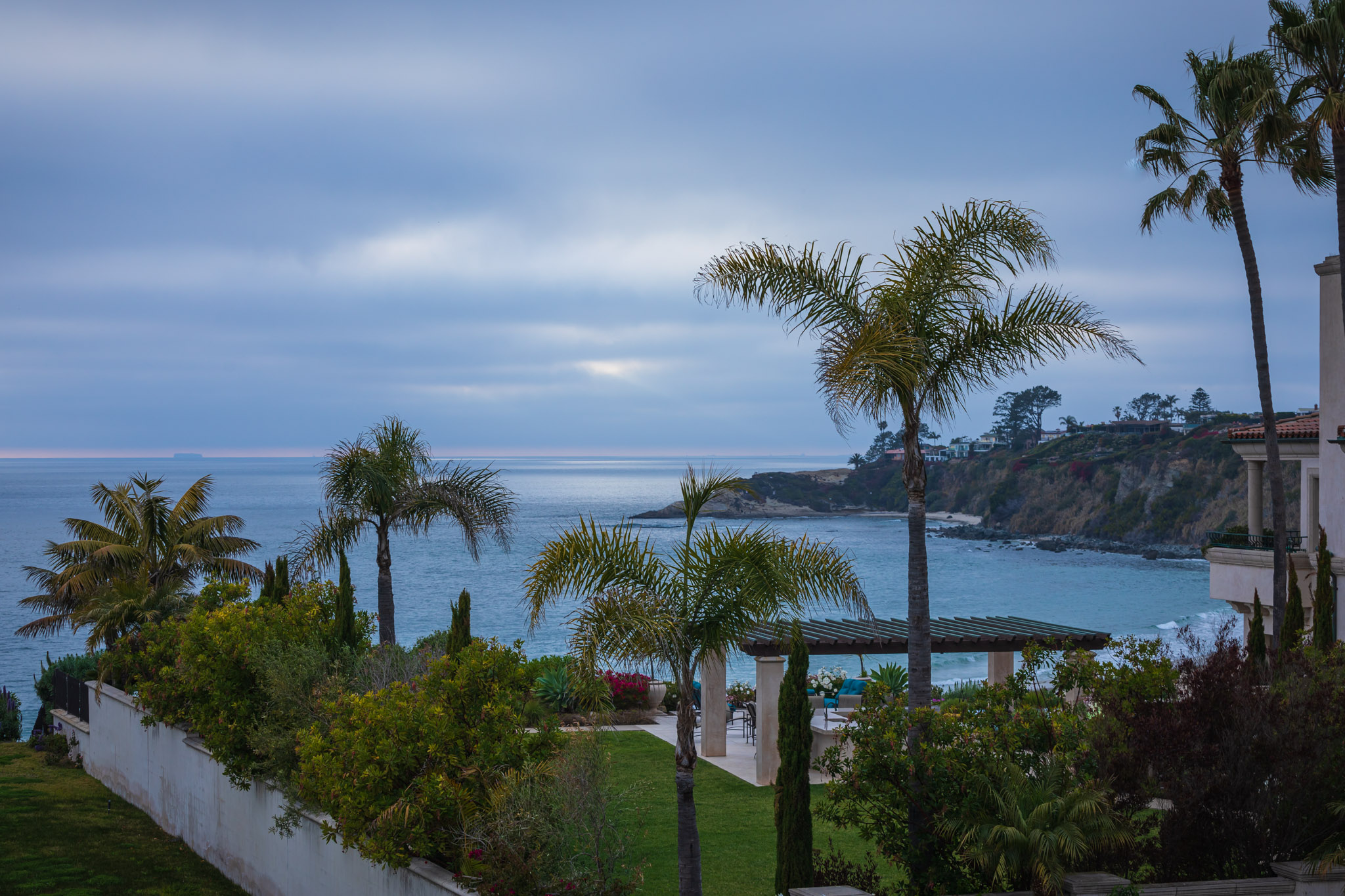 Scenic view of Dana Point bluffs, ocean, and palm trees at sunset