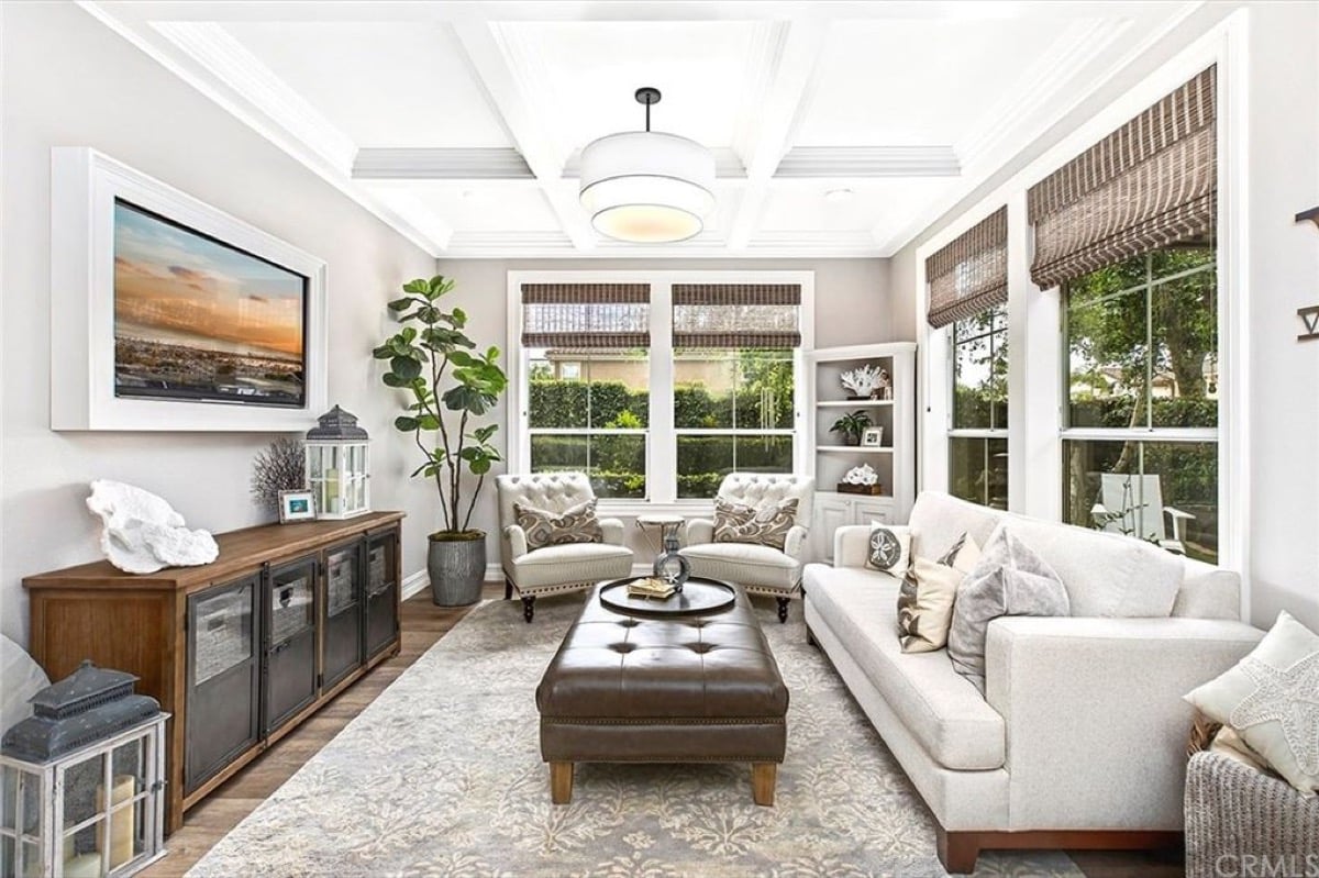 Luxurious living room in Aliso Viejo home with couch, chairs, and Roman shades