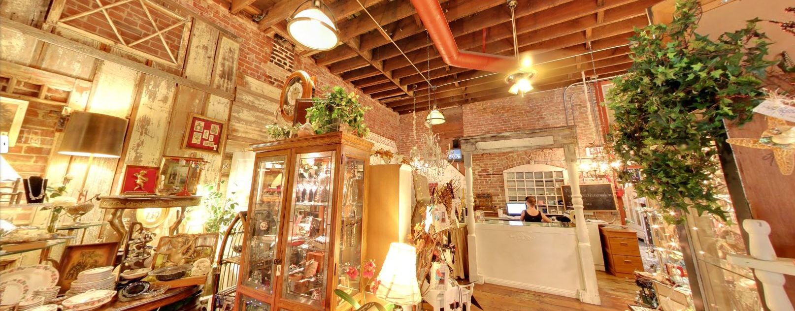 Rustic brick walled Interior of The Brick Basement Vintage Mall featuring vintage and antique goods for sale including a china