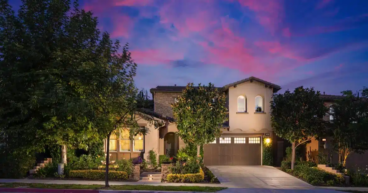 Evening view of an elegant Aliso Viejo luxury home exterior, highlighting the high-end real estate market and opportunities for buyers in fall 2024.