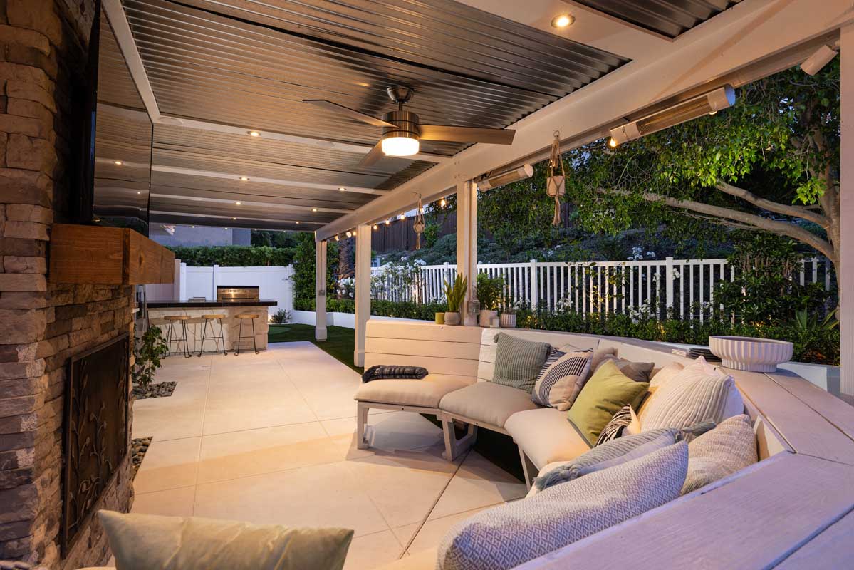 Outdoor living area with fireplace and built-in covered seating in the Laguna Niguel real estate property listed by top agents in the area Brad Feldman Group