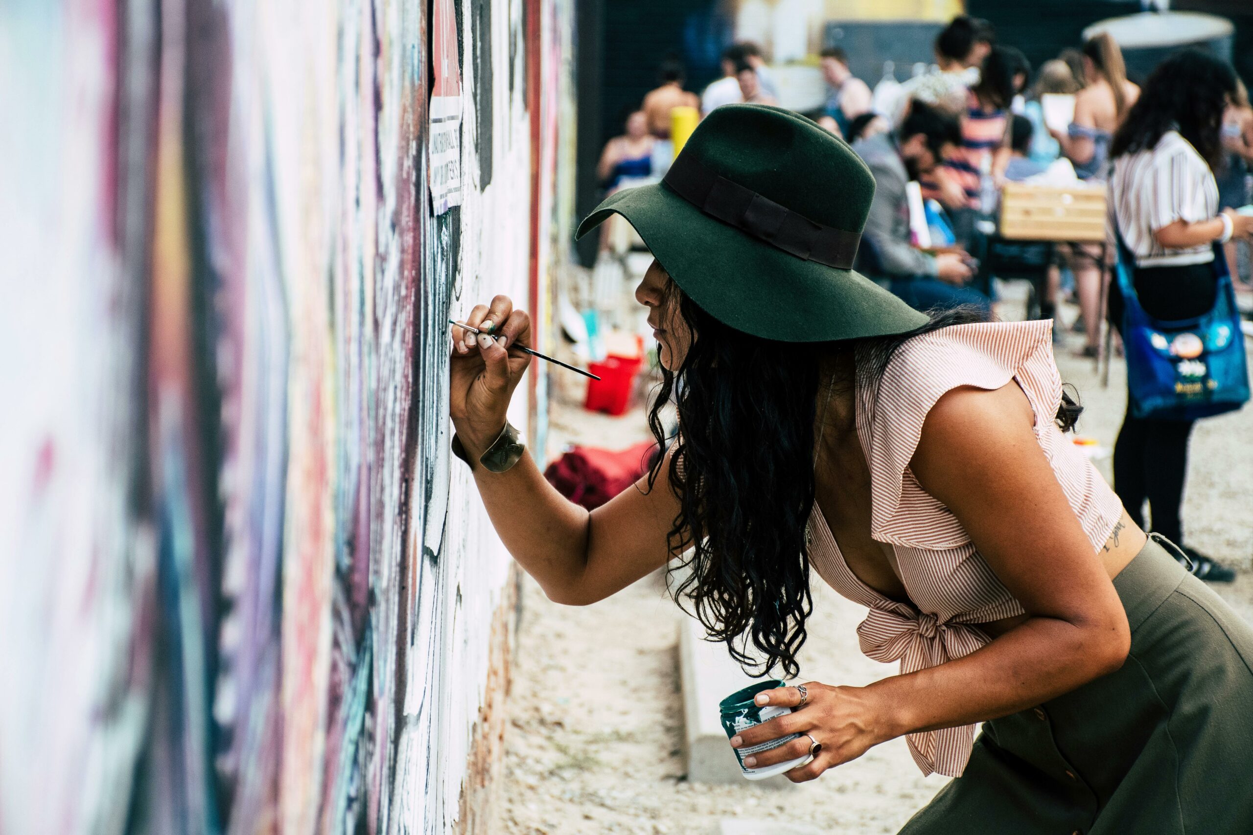 Woman painting on a wall of a Laguna Beach art festival event in summer 2025