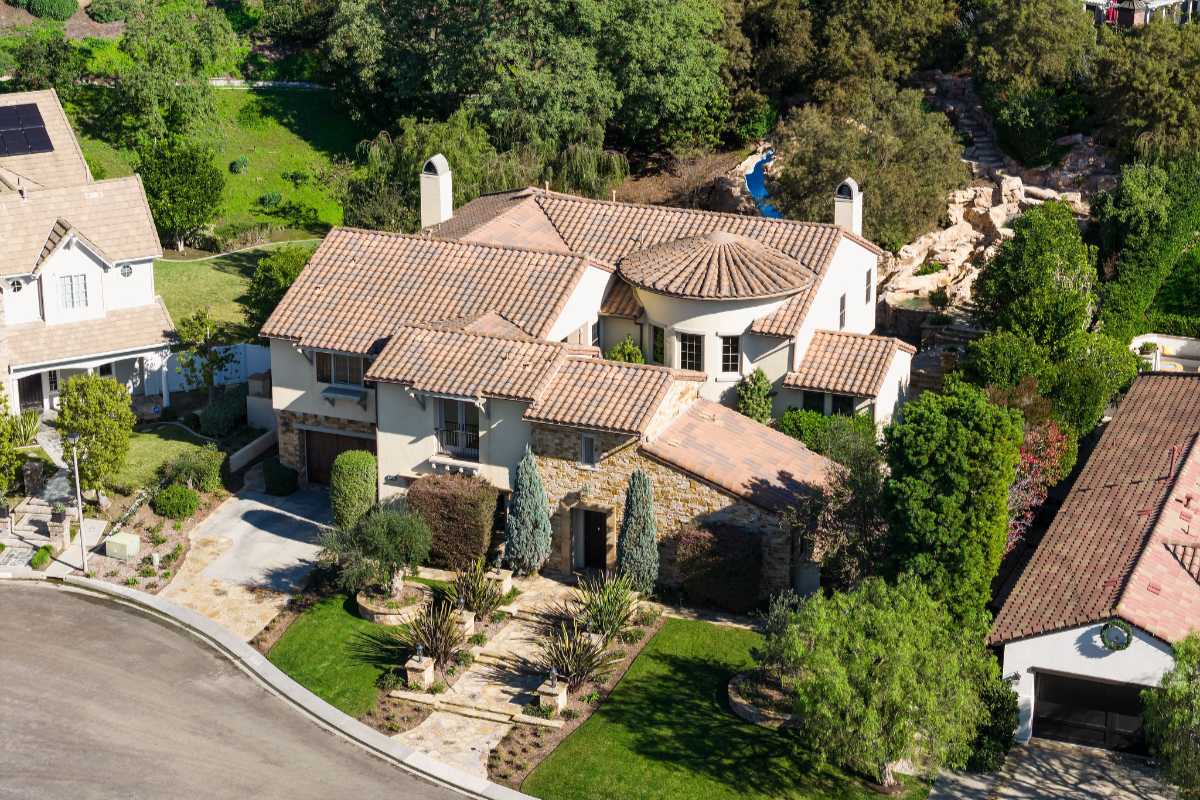 Aerial view of a Mediterranean style single-family home with more freedom when comparing house vs condo vs townhome for homebuyers in Orange County, budget price or luxury lifestyle